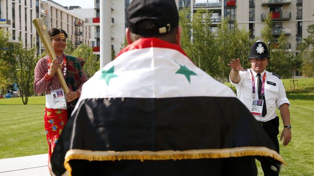 Un citoyen syrien attend pour être pris en photo avec la torche olympique à Londres