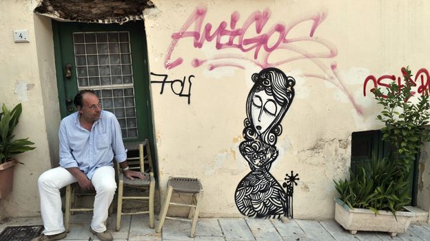 Un homme sur le pas de sa porte à Athènes