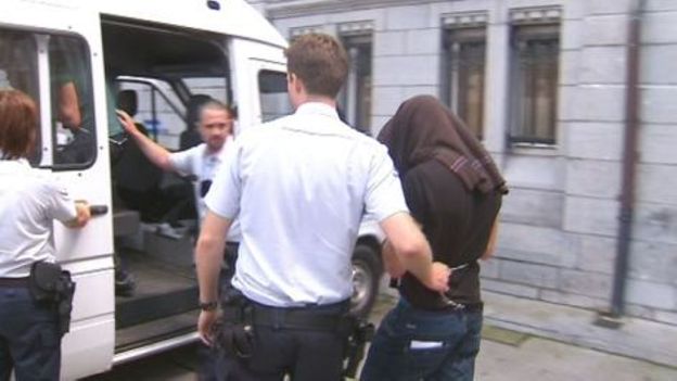 Un des suspects embarqué par la police.